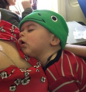 A baby sleeping on an airplane. 