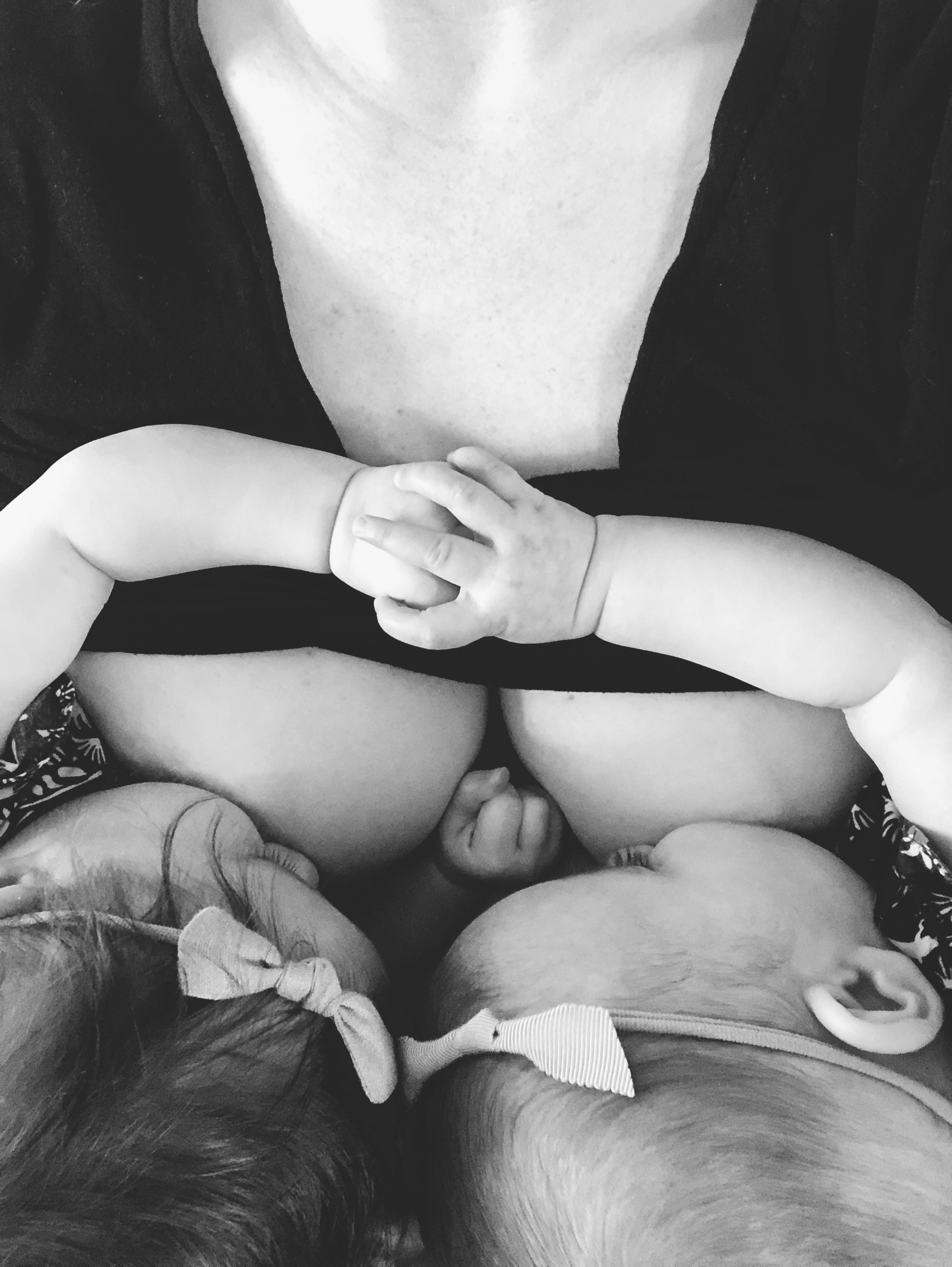 Breastfeeding Twins holding hands while nursing