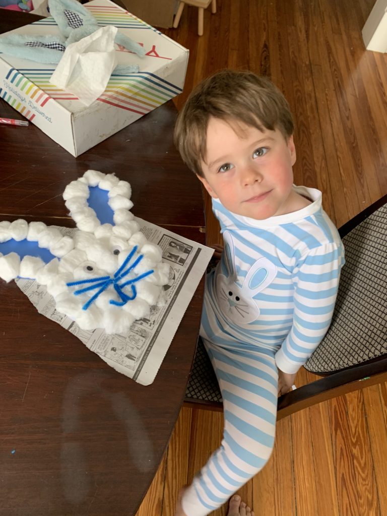 Boy shows Easter bunny craft made from cotton balls.