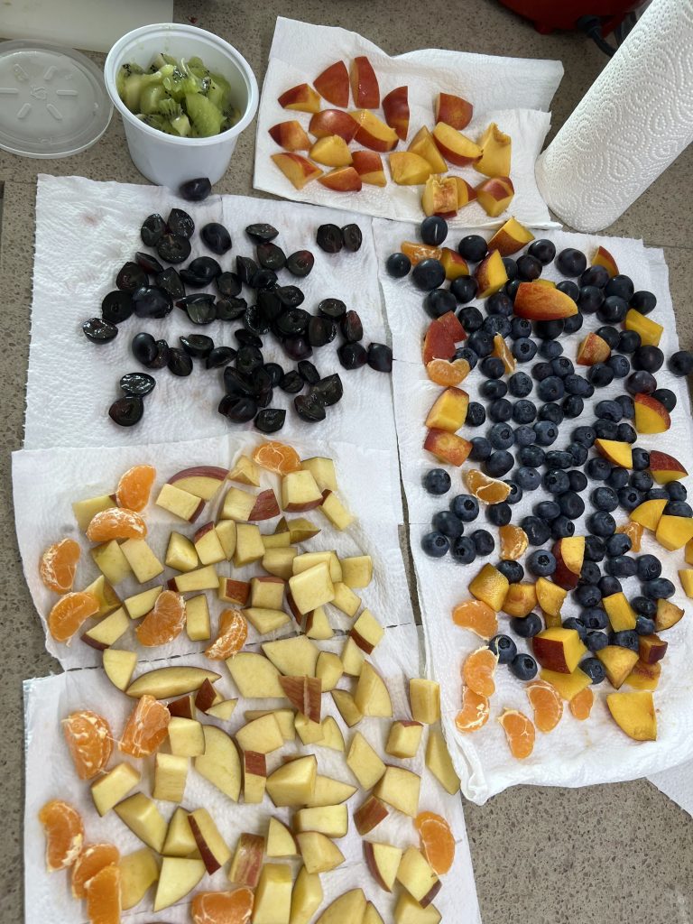 fun toddler activities: piles of cut fruit on paper towels on a kitchen counter