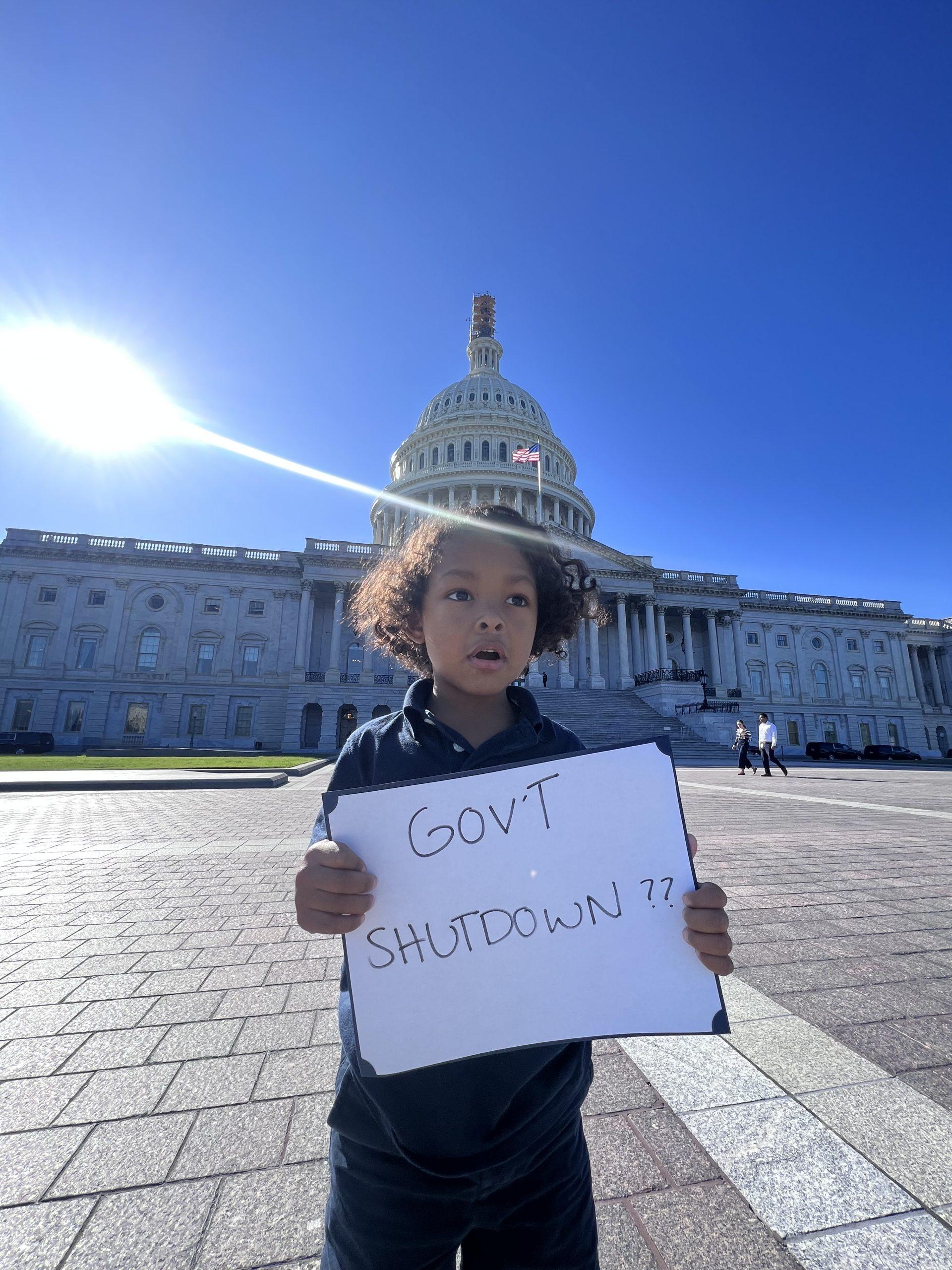 boy holding a Government shutdown sign in front of the capitol building