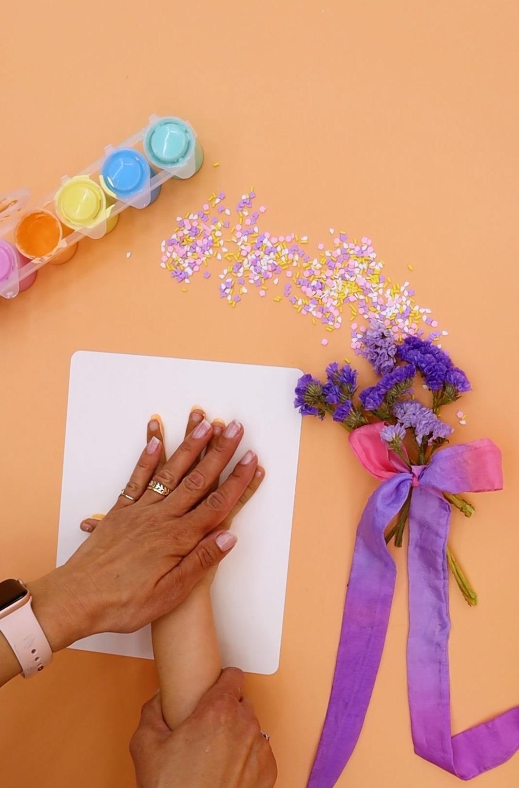 Pressing a child's hand onto a watercolor paper