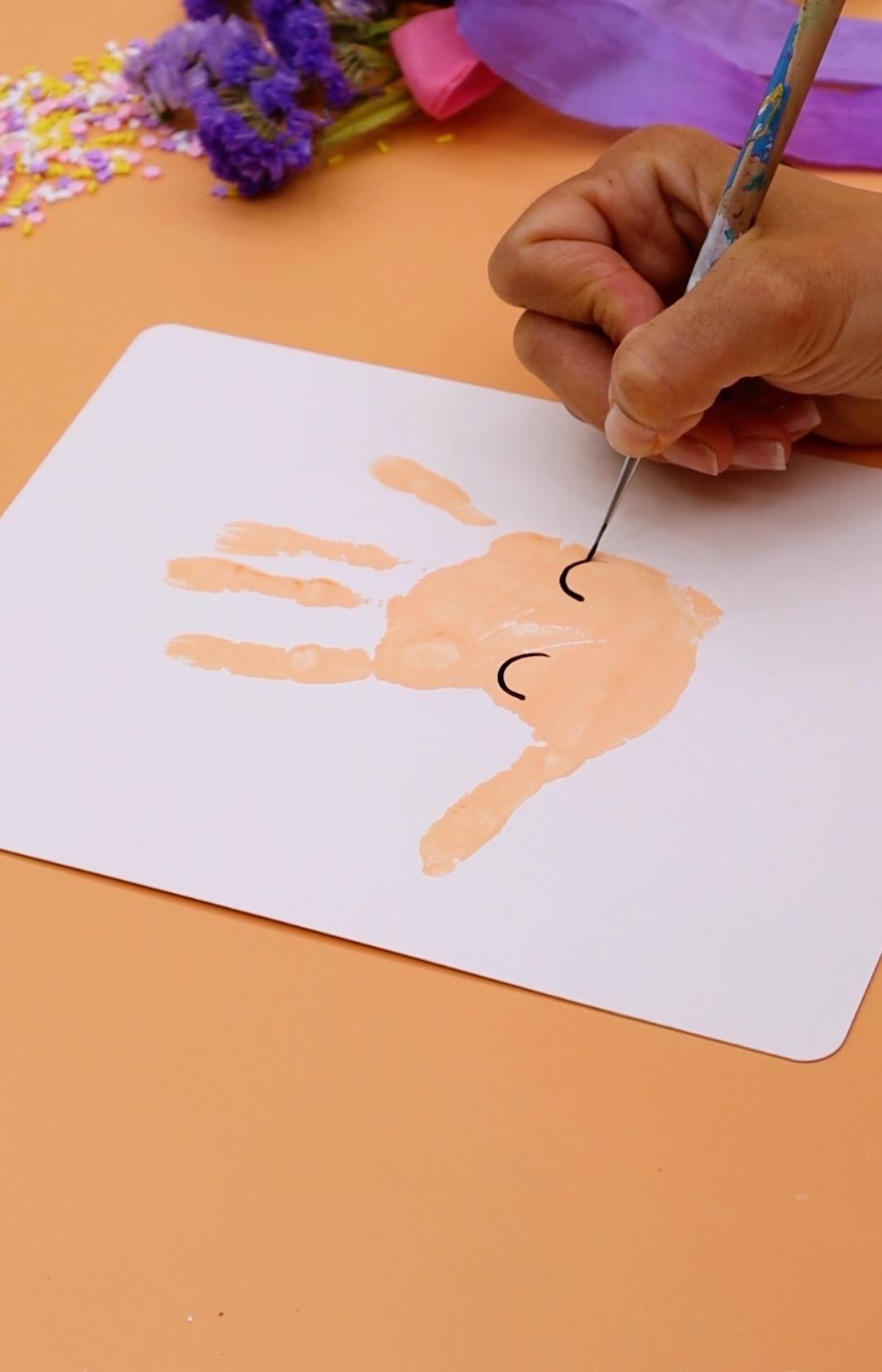 Drawing 2 arches onto a handprint 